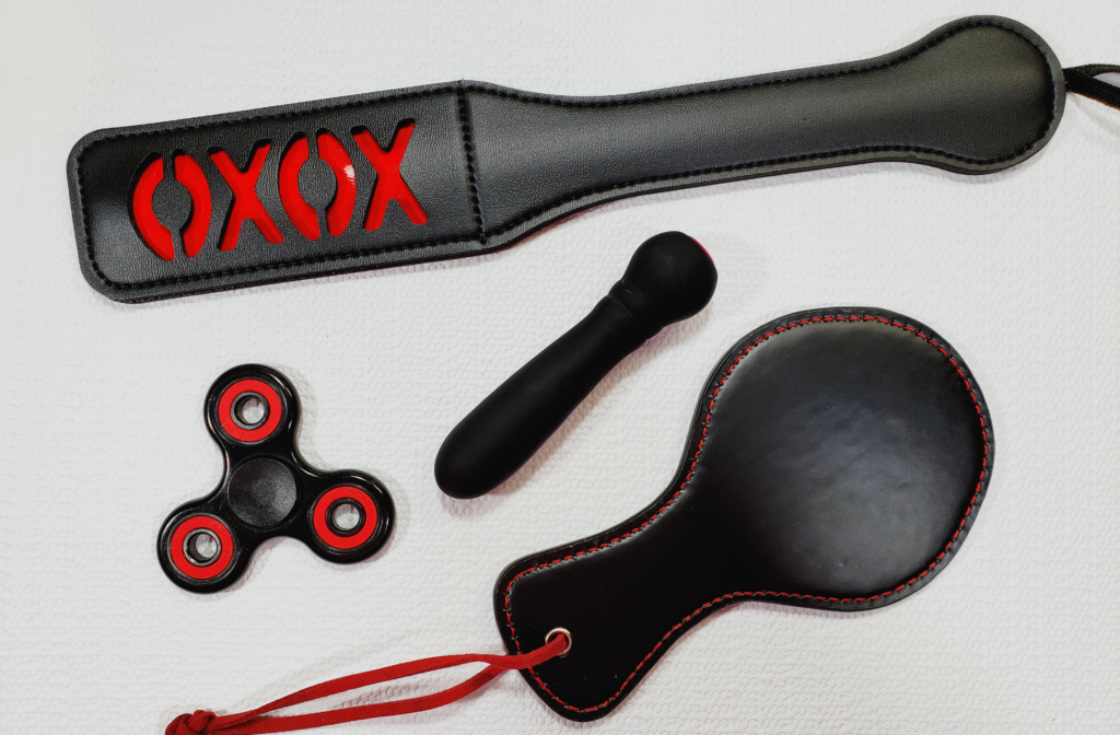 The Ultra Bullet laying in the middle of the XOXO Paddle, a fidget spinner, and a brandless paddle.