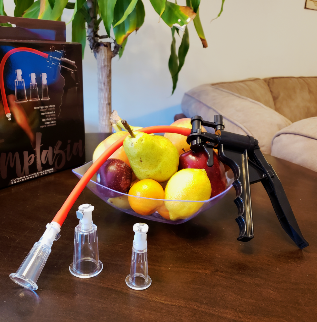 The Clit &amp; Nipple Pump sprawled over a bowl of fruit.