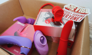 A box of oral sex simulator toys, with a sticker that says SheVibe.