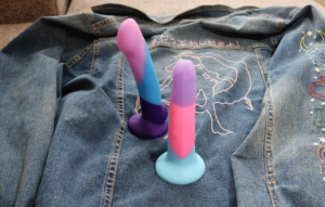 The D16 Purple Haze and D15 Vision of Love dildos standing upright on a jacket.