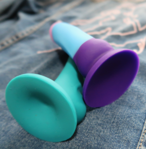 The D16 Purple Haze dildo sprawled over the Temptasia Reina to compare their suction cup bases.
