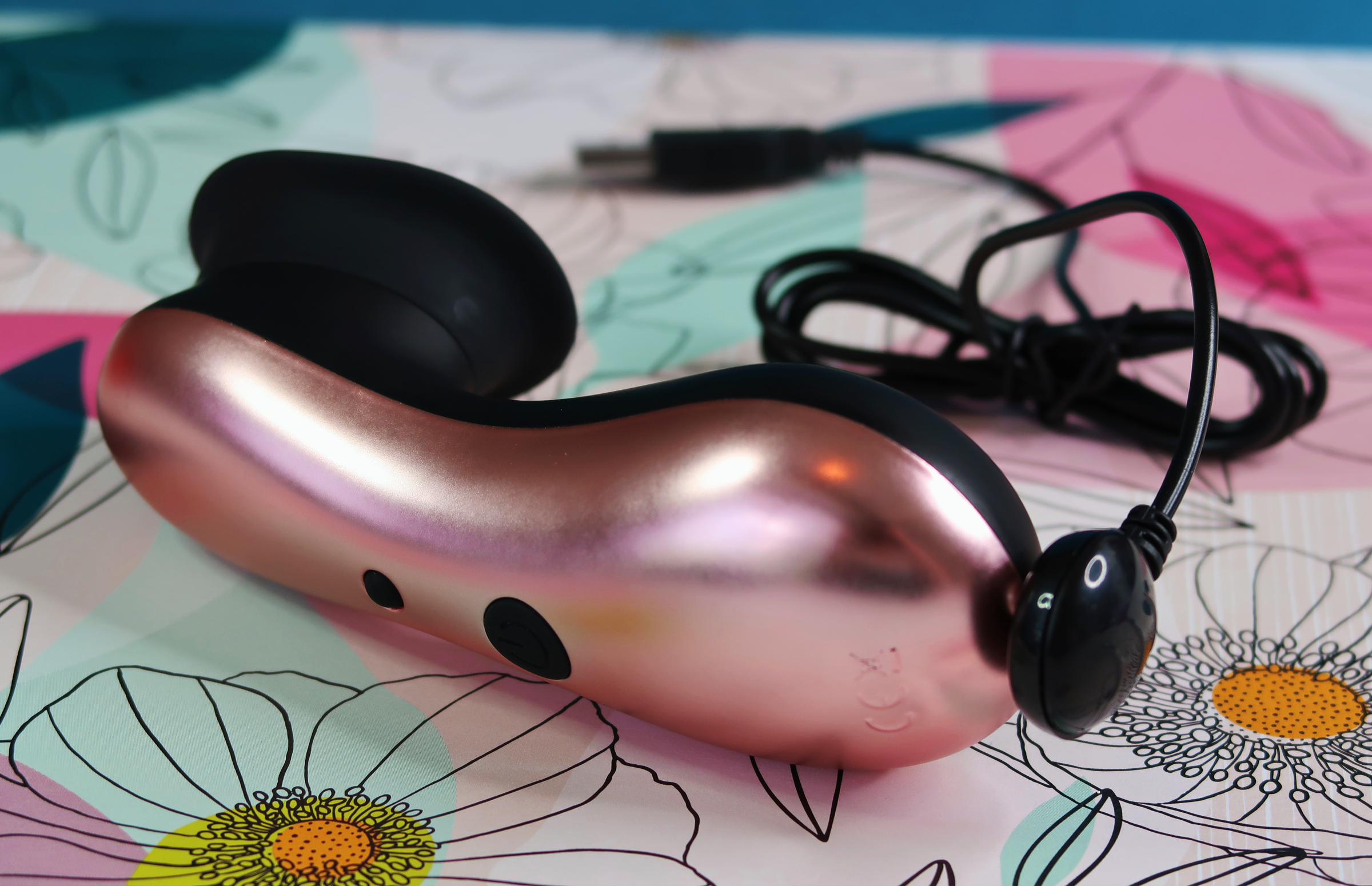 A close-up of the back of the Elegance Dreamy's rose gold back, as well as its usb charge cord.