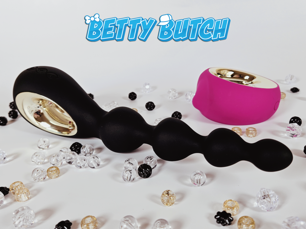 The Lelo Soraya Vibrating Anal Beads posed with the Lelo Oral Oral Sex Simulator vibrator, surrounded by scattered beads. 