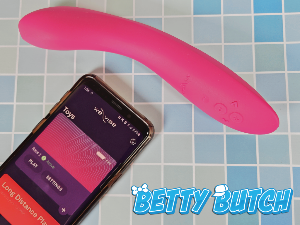The We-Vibe Rave 2 laying beside a Samsung phone to show the We-Vibe mobile app controls.